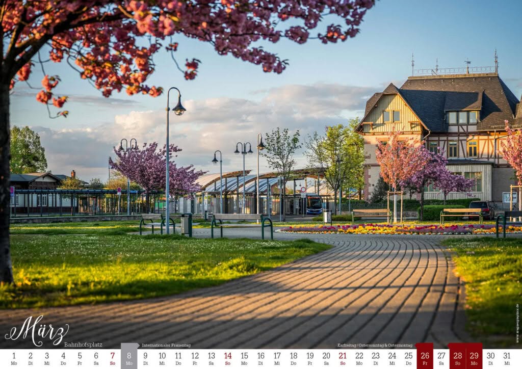 Kalender 2027, März: blühende Bäume am Bahnhofsplatz